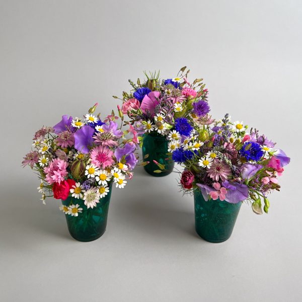Blumige Vasenfüllung in farbigem Glasgefäss